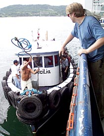 A pilot boat containing the Costa Rican customs officials approaches with some of the new crew of the R/V Revelle. Eric Wakeman catches the bow line. 