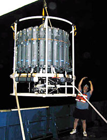 Shipboard Scientific Services Group Technician Dave Sims signaling the winch operator as the CTD is lowered into the water. Experiments such as these run around the clock; the ship never sleeps.