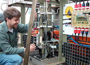 Scientist Jeff Mendez, preparing the towed camera for deployment. The sled holding the camera is towed on a wire cable behind R/V Atlantis roughly 5 meters above the sea floor. Every few seconds, the camera snaps a photograph; this helps scientist know whether the area being covered is worth investigating further.  