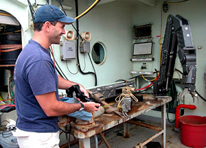 Alvin pilot Bruce Strickrott using a joystick to test a new mechanical arm. The joystick will eventually reside in the sub. Each part of Alvin is regularly inspected, and often replaced. 