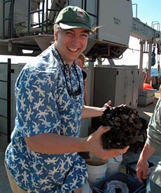 Chief Scientist Jess Adkins holds the prize catch of the day, and perhaps of the cruise: the largest single Desmophyllum cristagalli coral he’s ever seen.  