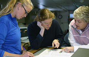 From left, doctoral students Kris Ludwig and Deb Glickson, with Chief Scientist Deb Kelley, discuss seafloor maps they are making of the Main Endeavour hydrothermal vent field. 