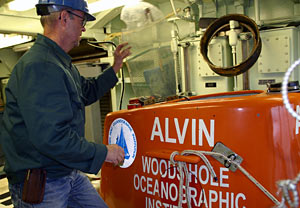 Electrical Technician George Meier with the Alvin group checks that the sub’s sail lid is working properly. During a dive, the lid keeps rocks that may fall from tall undersea chimneys from banging into the hatch. 