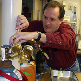 Microbiologist Jim Holden of the University of Massachusetts replaces flow regulators he had removed from gas tanks in his lab when the ship rocked in high seas Friday. Though the tanks are secured to tables, capping helps prevent an explosion if they tip. He uses the nitrogen and carbon dioxide gases to feed microbes collected from hydrothermal vents.