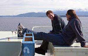 During the trip in from the Juan de Fuca Ridge through the Strait Juan de Fuca, Science Technician Sheryl Bolton and Graduate Student Ben Larson relax on the deck overlooking the bow.  