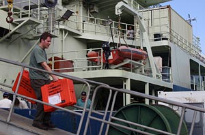 Ben Larson, a graduate student at the University of Washington, unloads science equipment from the ship at the dock in Seattle. 