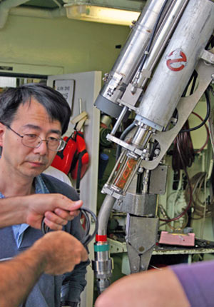 Chemist Kang Ding makes final checks on a special chemical and temperature instrument mounted on Alvin, known as �Ghostbuster� (named by Alvin pilots who said it reminded them of ghost-battling tools in the film Ghostbusters). Chemists use Ghostbuster to measure fluid temperature and composition.