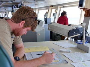 2. On the bridge, third mate Jacob Fleming makes notes in the ship�s log. Two people are always on watch on Atlantis; this morning Jacob was joined by seaman Jerry Graham. (Photo by Amy Nevala)