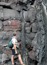 Greg Kurras, a student at U. Hawaii, SOEST, standing at the beach cliff at the shoreline where the Pu’u Oo eruption was entering the sea in June, 2001.