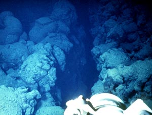  Submarine pillow flows along an eruptive fissure near the crest of the East Pacific Rise at 2600 meters depth. Scale across photo is about 4 meters. Camera across the foreground is one of Alvin’s video cameras. Photo by Dan Fornari, WHOI. 