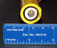 Cross section of the fiber optic cable that connects Medea to ROV Jason. The outer yellow and black plastic layers protect it from abrasion. The white material called Spectra provides strength but is very light. The three smaller colored wires in the middle contain the glass strands.